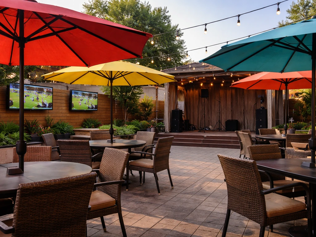 Outdoor patio seating under bright umbrellas, with a visible live-music stage and patio TVs in the background.