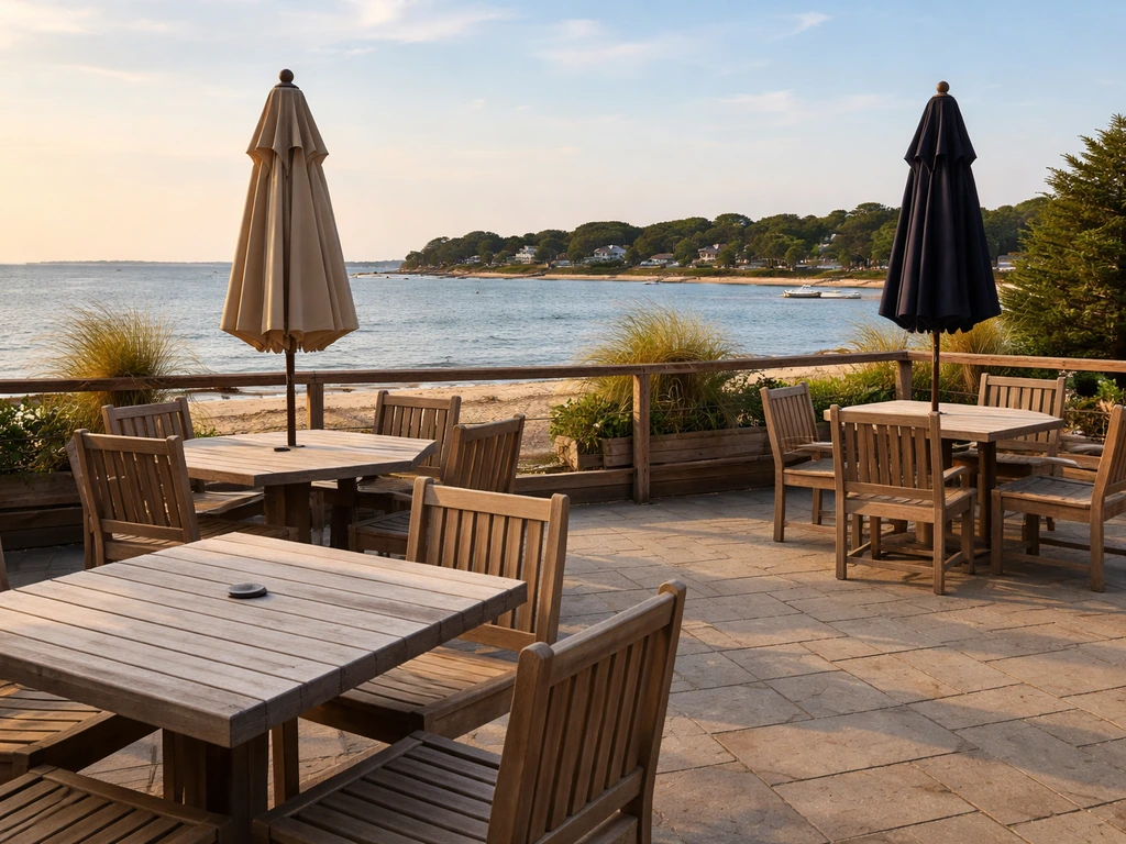 View from a patio toward Onset Beach water with umbrellas and outdoor seating in warm light.