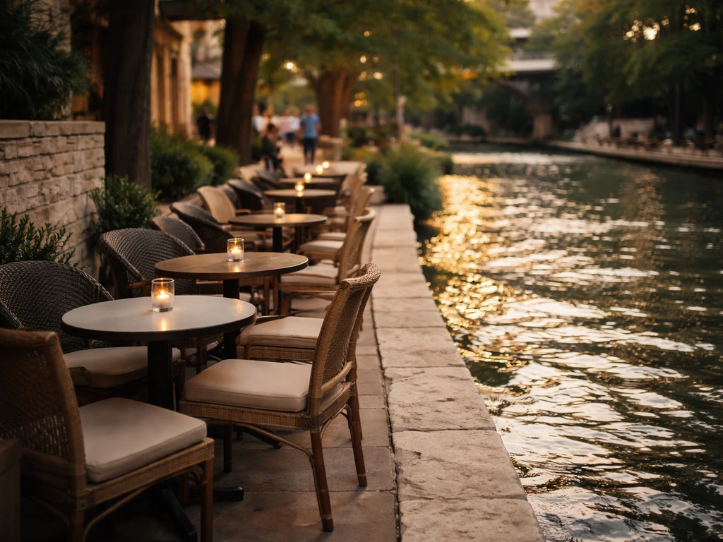 Overhead view of an empty River Walk patio by the water, showing relaxed seating and strolling atmosphere